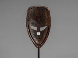 a wooden mask on a stand with a white background