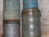 trois vieux récipients en métal posés sur une étagère dans une pièce