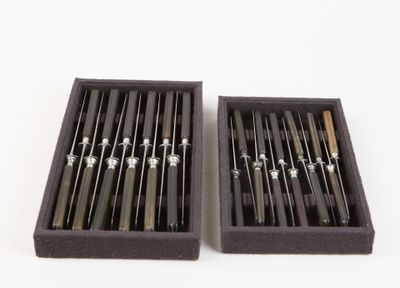 two black and silver chopsticks in a black box on a white background
