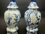 une paire de vases bleus et blancs surmontés d'oiseaux