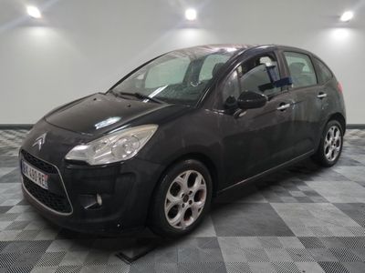 la petite voiture noire est garée sur un sol en damier