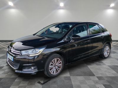 une voiture noire est garée sur le sol en damier d'un garage