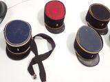 several hats are lined up on a white table with a black ribbon