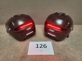 une paire de casques de moto munis de lumières rouges et portant des numéros