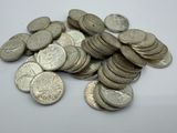 a pile of silver coins sitting on a white surface