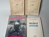 three books are sitting on a table with a white background