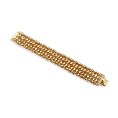 gros plan d'un bracelet en or sur fond blanc