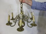a man that is holding a chandelier in his hand