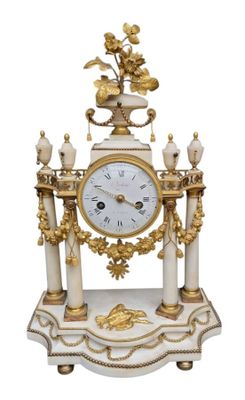 une horloge blanche et or posée sur une table