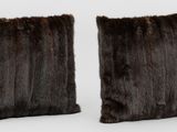 deux coussins en fourrure marron posés l'un sur l'autre