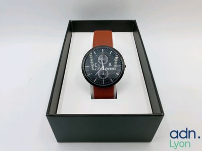 l'image d'une montre dans une boîte sur une surface blanche
