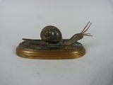 statue d'un escargot posée sur un socle en bois