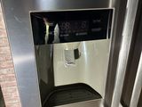 a stainless steel refrigerator with a digital display on the door