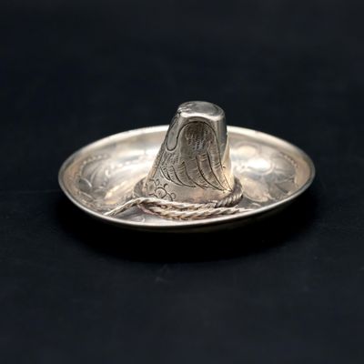 a silver coin with a bird on it on a black surface