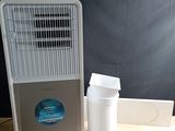 a small air conditioner sitting on a table next to a trash can