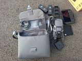 un sac contenant des appareils électroniques et un téléphone portable, posé par terre