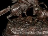 statue of a man on a horse with a bull in the background
