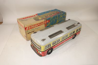 un petit bus en plastique posé à côté d'une boîte
