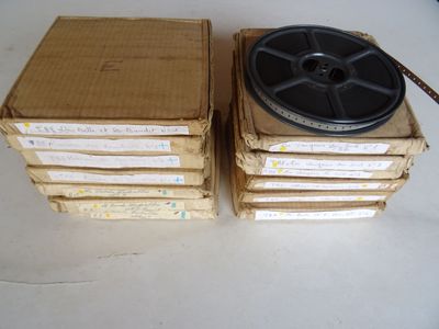Plusieurs cartons contenant de vieilles bobines sont empilés les uns sur les autres