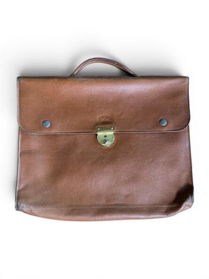 porte-documents en cuir marron sur fond blanc, avec une découpe au niveau de la poignée