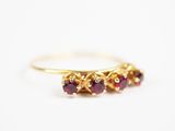 un gros plan d'une bague en or sertie de trois rubis
