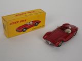 an old red toy car sitting next to a boxed box