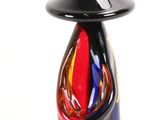 a glass vase with a black top and a red base