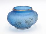 a blue vase with a gold rim sitting on a white surface