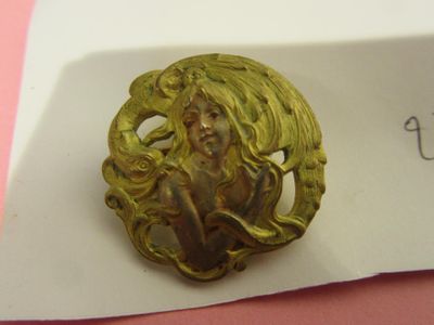 a picture of a gold brooch with a woman on it