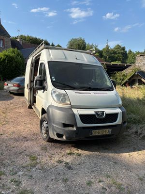 une camionnette blanche garée sur le bord d'un chemin de terre
