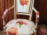 a white chair with a red and yellow flower on it