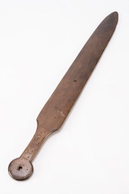 an old wooden knife on a white surface with a white background