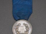 a close up of a medal with a blue ribbon around it