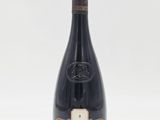une bouteille de vin posée sur une table blanche
