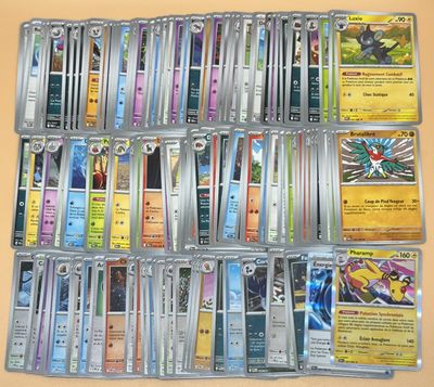 une photo montrant une collection de cartes Pokémon posées sur une table