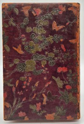 un vieux livre dont la couverture est ornée d'un motif floral