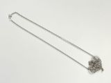 silver necklace with a chain and a flower on a white background