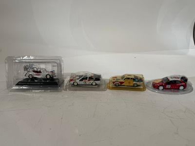 four toy cars are lined up in a row on a table