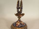 two birds that are sitting on top of a candle holder
