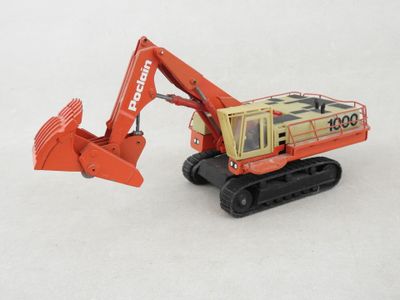 a toy excavator that is sitting on a white surface