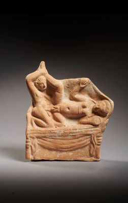 an ancient statue of a woman and child on a bed