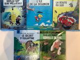 quatre livres pour enfants sont alignés sur une surface blanche
