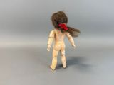 a wooden doll with a red bow on it ' s head