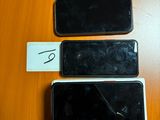 trois téléphones portables posés les uns à côté des autres sur une table en bois