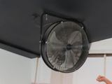 a man standing in front of a fan in a room