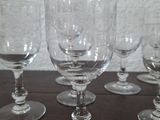 several empty wine glasses sitting on a wooden table with a white wall in the background