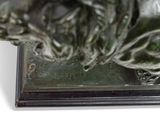 a statue of a dog that is sitting on top of a book