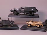 quatre modèles différents de véhicules militaires exposés sur une table