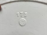 a person holding a white plate with a smiley face on it