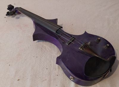 un violon violet posé par terre